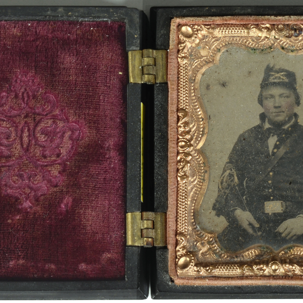 Sedící voják, kolorovaná nestandardní ambrotypie, adjustace typ: Union Cases USA - používáno od roku 1854, uložena v černé plasticky zdobené kazetě, v oválu orel + nápis CONSTITUTION AND THE LAWS Sedící voják, kolorovaná nestandardní ambrotypie, adjustace typ: Union Cases USA - používáno od roku 1854, uložena v černé plasticky zdobené kazetě, v oválu orel + nápis CONSTITUTION AND THE LAWS